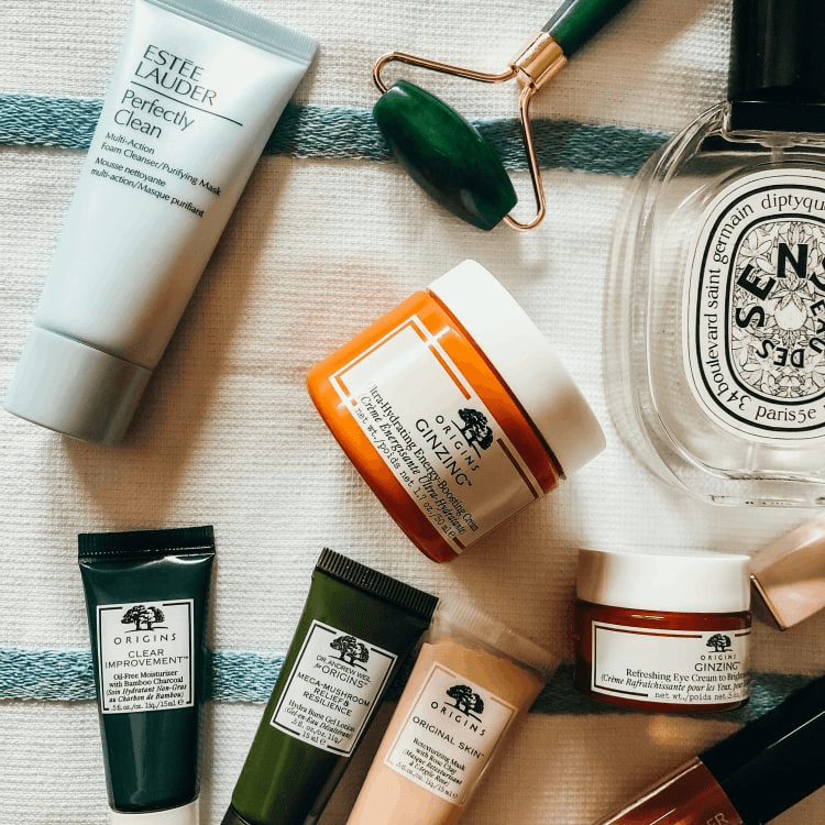 Cosmetics products laying on a table cloth.